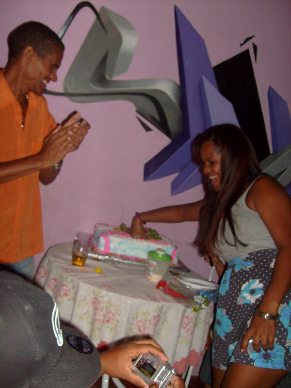 Mônica, à direita, cortando o bolo do aniversário