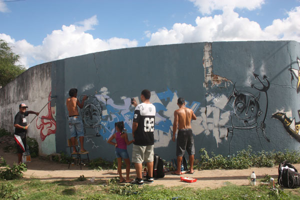 Espectador fotografa as intervenções dos grafiteiros Blot (Serrinha e Medo e Fera (Conceição do Coité)