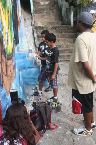Carol Garcia registra o momento em que o grafiteiro Bigod orienta os garotos a manusear o spray 