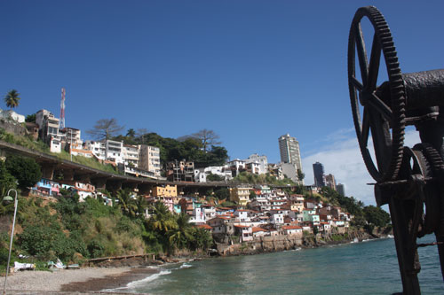 (E) Vista parcial da Avenida Contorno; (ao fundo) Comunidade Solar do Unhão; (D) Detalhe da engrenagem na área do MAM